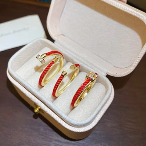 Three-piece gold-tone ring set featuring nail design and red woven details in a gift box