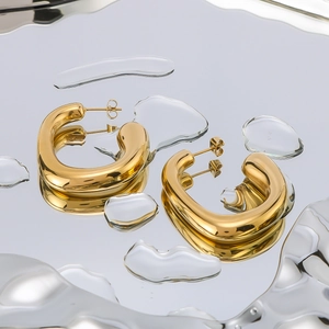 Irregular C-shape geometric gold earrings with liquid metal effect on rippled background