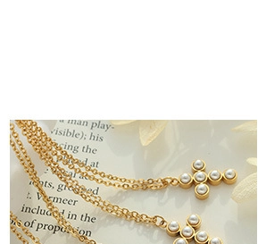 Close-up of gold cross pendants with white pearls on a vintage paper background