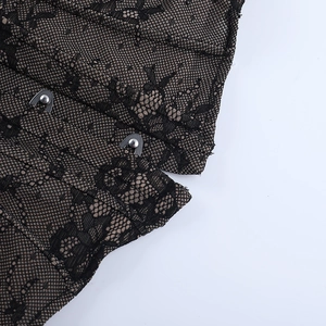 Close-up of black floral lace fabric with silver metal eyelet hook and eye closures