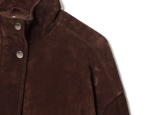 Detail shot of deep brown suede fabric texture and silver metal buttons on collar