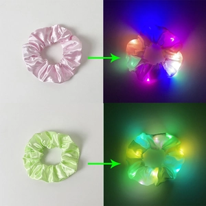 Detail of pink and green LED scrunchies showing glowing lighting effects in darkness
