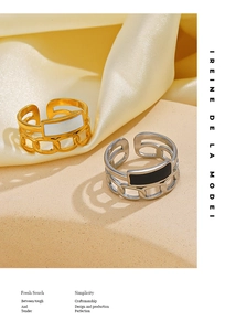 Detail of adjustable chain rings with black and white enamel inlays on silk background
