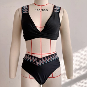 Detail of black two-piece bikini with ethnic beaded patterns on straps and waistband