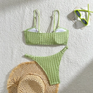 Nahaufnahme von hellgrünem Bikini-Stoff mit Rippenmuster und passenden Accessoires