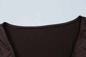 Détail du col carré et bordure en dentelle noire sur haut marron à manches longues