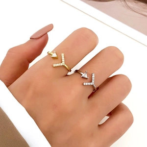 Close-up of gold and silver geometric arrow rings with micro-pave diamond details