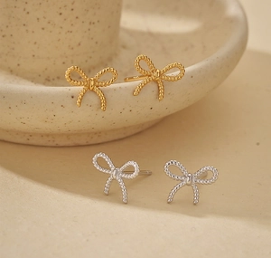 Detailed view of 925 silver twist bow stud earrings in gold and silver finishes