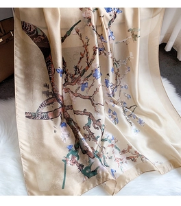Detailed texture of champagne silk scarf with almond blossom print on plush background