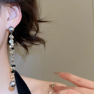 Close-up of silver fringe tassel earrings with beads on a model for elegant look