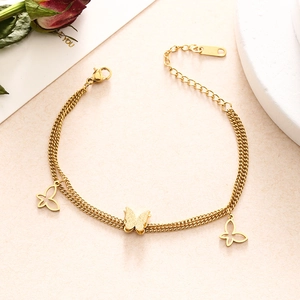 Detail of double-layer golden butterfly chain bracelet with hollow and matte charms