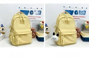 Detail of yellow nylon student backpack featuring front pocket and white rabbit charm