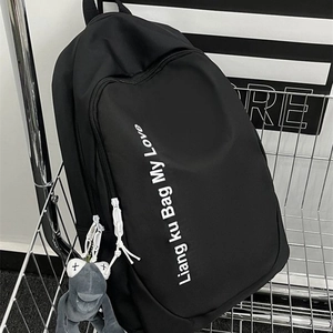 Minimalist large capacity black backpack with white slogan and plush charm in a cart
