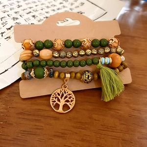 Detail of bohemian sandalwood beaded bracelet set with tree of life charm and tassels