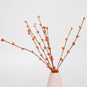 Detail of orange artificial berry stems in a modern pink ceramic vase for home decor