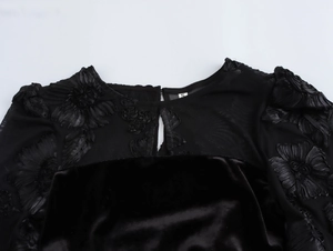 Close-up of black velvet dress with floral mesh applique and size S collar tag