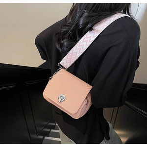 Mini crossbody bag featuring woven texture, metal lock closure, and wide patterned strap.