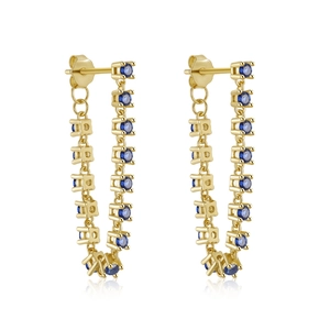 Close-up of golden chain earrings featuring elegant blue round gemstones in claw settings