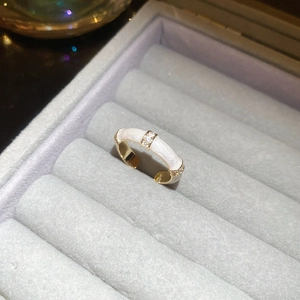 Detailed macro view of an 18k gold-plated double-layer ring with zircon and white enamel