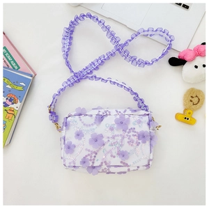 Detail of floral crossbody bag with purple flower appliques and ruffled gauze strap
