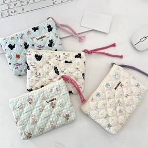 Detailed view of quilted cotton floral cosmetic bags with cute cartoon patterns and zippers