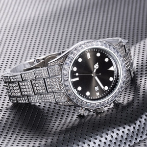 Macro shot of silver diamond-encrusted bezel with black dial and calendar display window