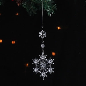 Macro shot of transparent acrylic snowflake pendant with festive bokeh background lighting