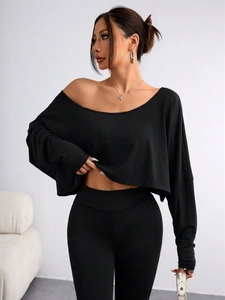 Detail of black off-the-shoulder cropped top showing knit fabric texture and slim fit