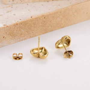 Golden heart-shaped stainless steel stud earrings with textured surface on stone decor