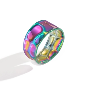 Macro shot of iridescent colorful wide ring with unique pebble-textured metal surface