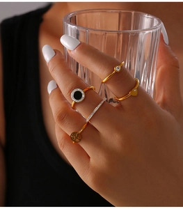Close-up of a 5-piece 18K gold plated tree of life ring set worn in a lifestyle setting