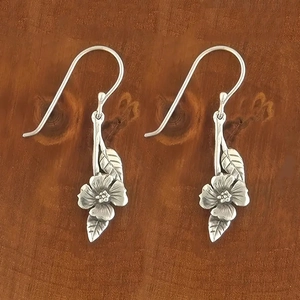 Close-up of vintage silver floral leaf earrings featuring intricate petal and vein textures