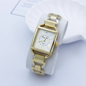 Détail macro d'une montre à quartz dorée carrée avec chiffres romains et bracelet chaîne