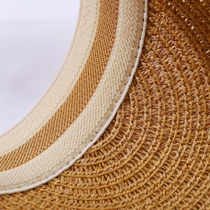Detailed macro view of woven straw sun hat interior with striped sweatband reinforcement