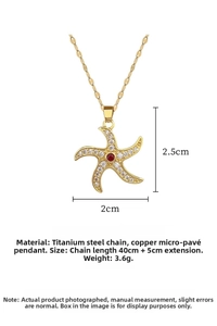 Detail of spinning starfish pendant with white zircon and red center stone on gold chain