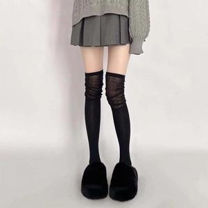 Detail of black over-the-knee socks featuring translucent layered fabric texture