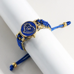 Detail of blue woven quartz watch featuring golden heart-shaped dial with crystals