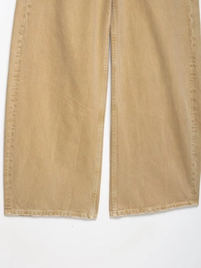 Detaillierte Makroansicht vom Saum der khakifarbenen Denim-Hose mit präzisen Nähten