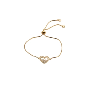 Détail du bracelet ajustable doré avec breloque en forme de cœur sertie de zircons brillants