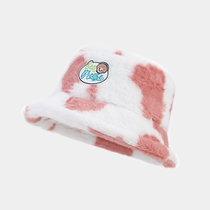 Detail view of pink cow pattern plush bucket hat featuring a sea breeze seashell patch