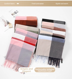 Detailed view of plaid cashmere-like scarves with fringe tassels in various colors