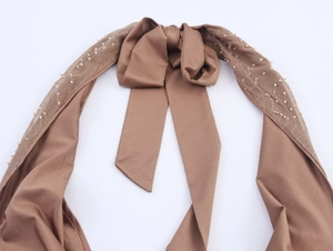 Close-up of brown satin halter neck top with mesh panels, 3D bow, and beaded details