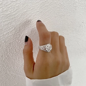 Close-up of silver S925 sterling silver ring with irregular hammered lava texture design