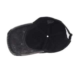 Internal view of a washed black cotton baseball cap showing lining and 100% cotton label