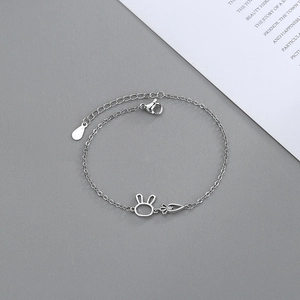Detailed close-up of rabbit and carrot charms on silver bracelet with O-link chain