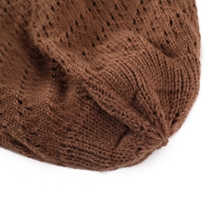 Macro view of coffee brown knit beanie showing detailed hollow pattern and soft texture