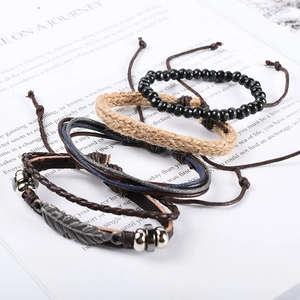 Detailansicht von Vintage-Lederarmbändern mit Metallblatt-Anhänger und Holzperlen