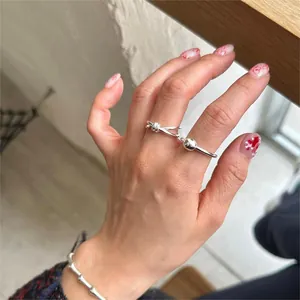 Detailed shot of S925 sterling silver knotted ring and beaded bracelet on hand