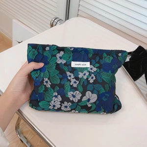 Blue and green floral jacquard makeup bag with simple wish label on black canvas