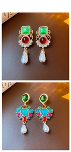 Close-up of vintage gold earrings with multi-colored gemstones and waterdrop pearls